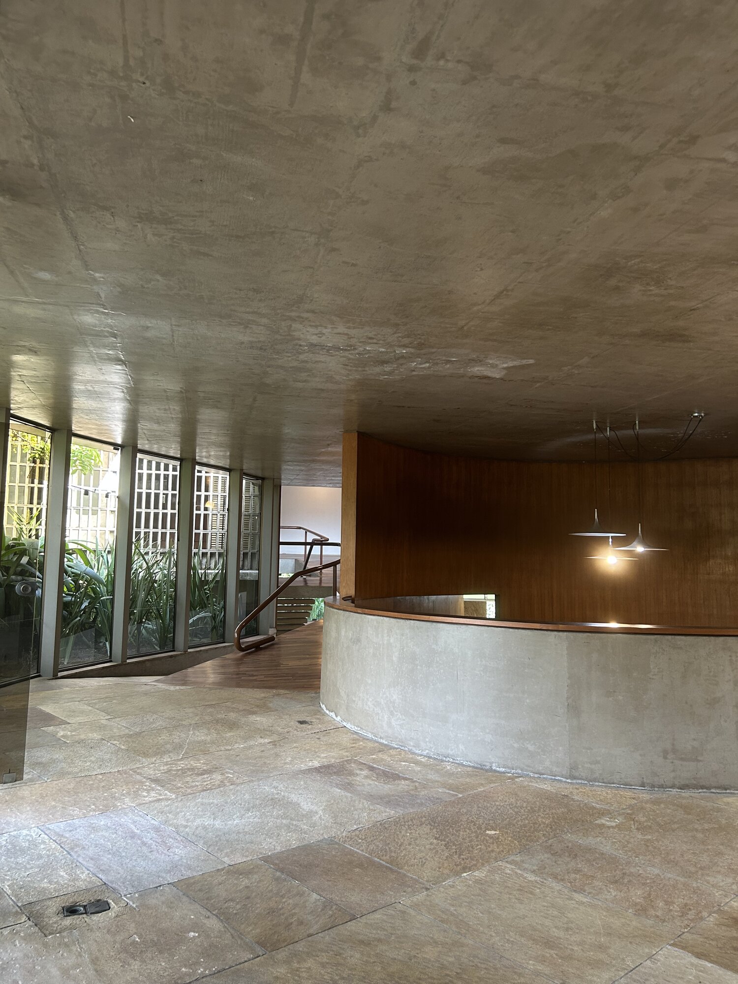 Hall central com curvas de concreto e madeira